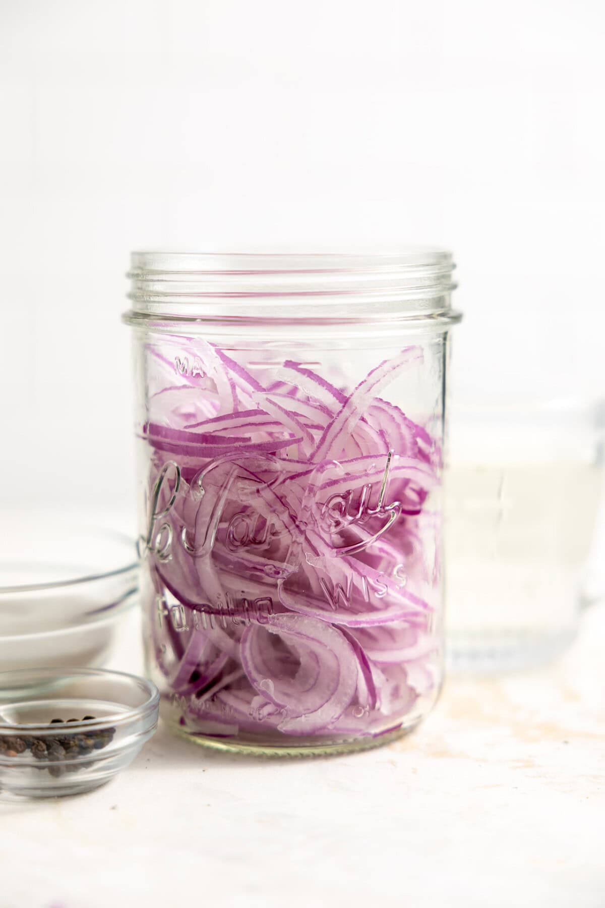 Thinly sliced red onions in a jar. 