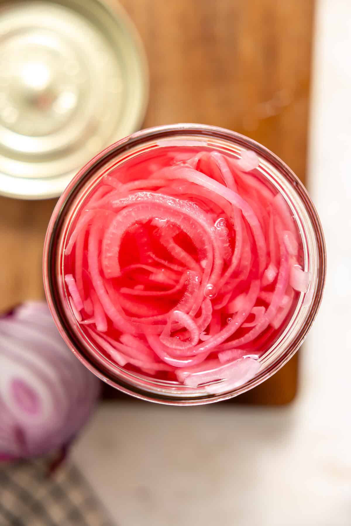 Overhead look at pickled red onions in a jar. 