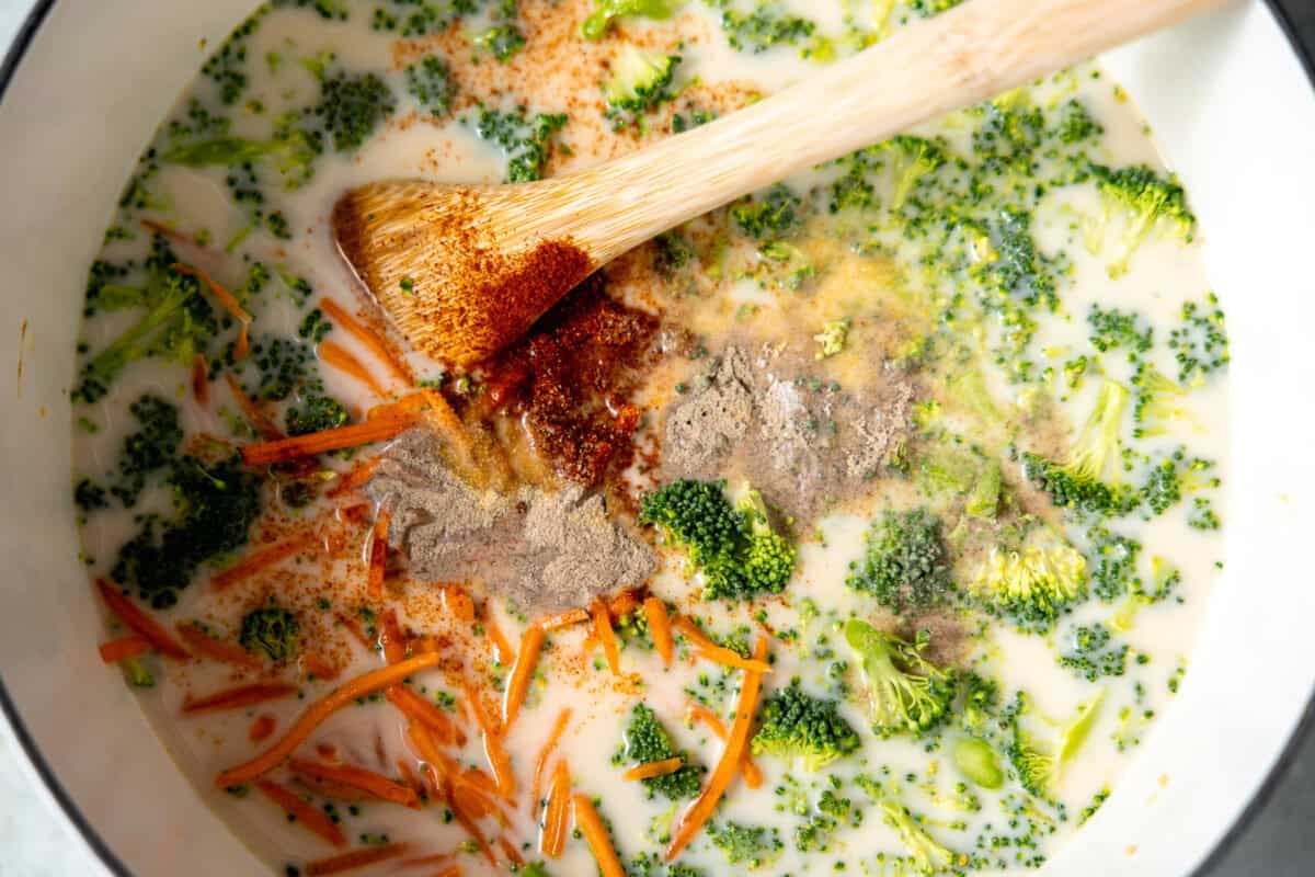 Broccoli, carrots, and spices added to broth for making a pot of soup. 