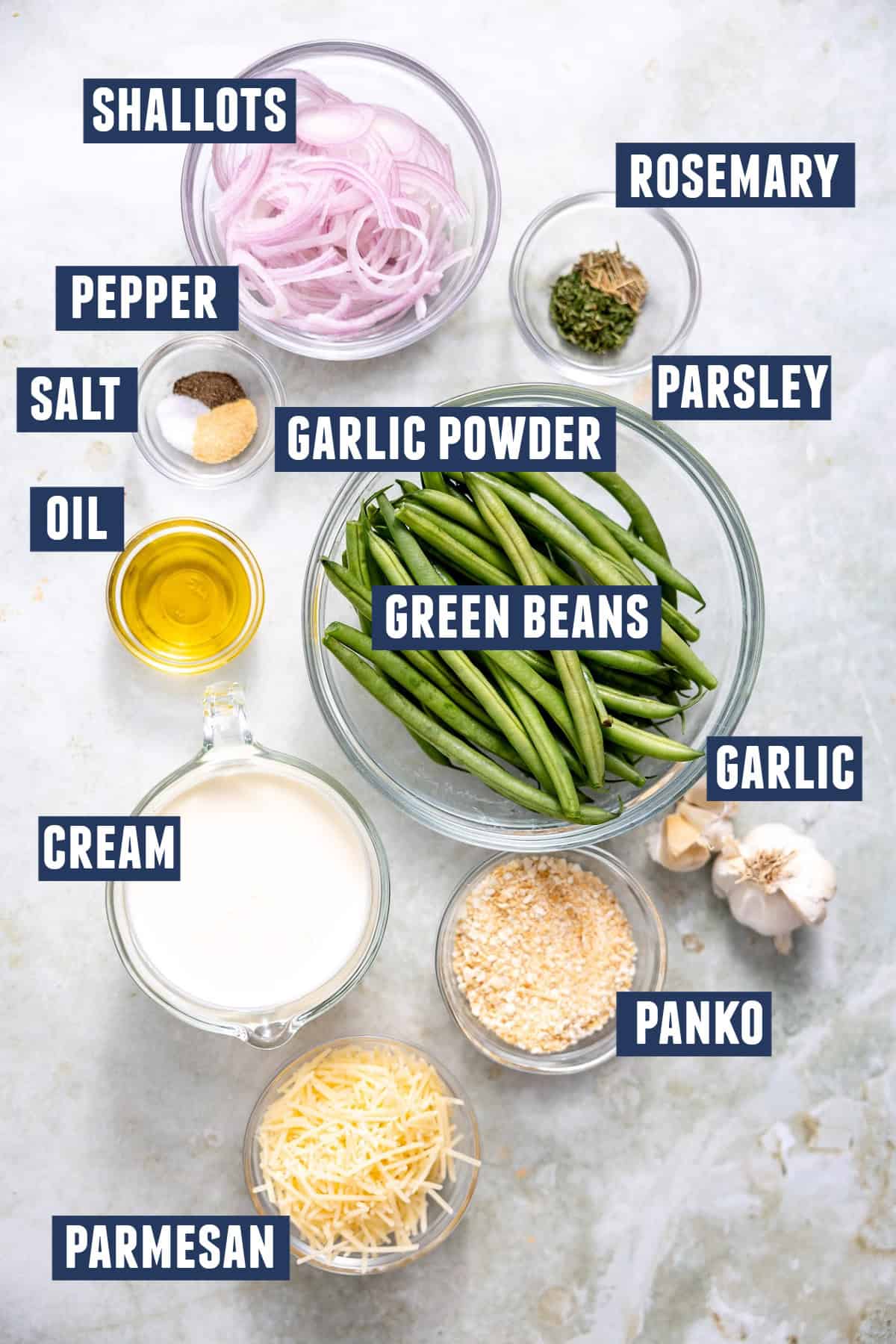 Ingredients needed to make creamed green beans with a crisp shallot topping. Including: green beans, shallots, cream, panko, oil, garlic, herbs, salt, pepper, parmesan cheese.