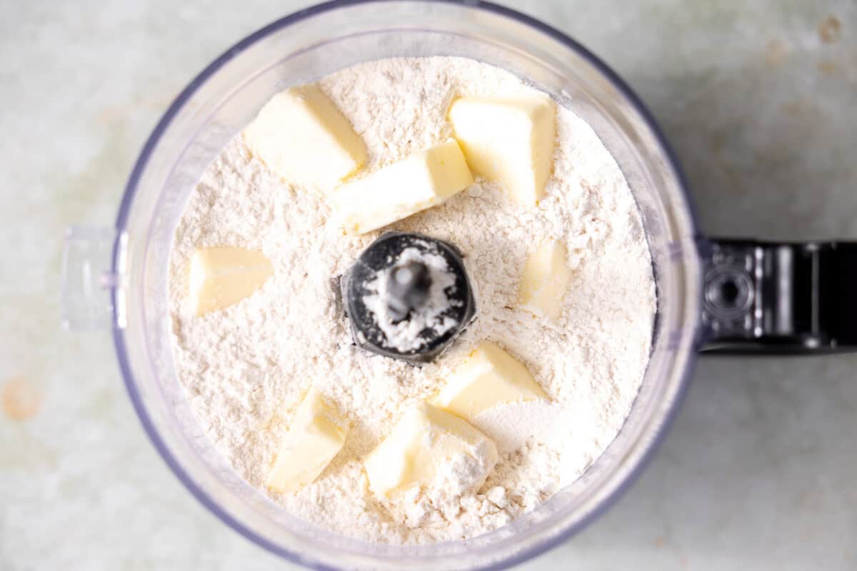 Dry ingredients in a food processor with cubed butter added. 