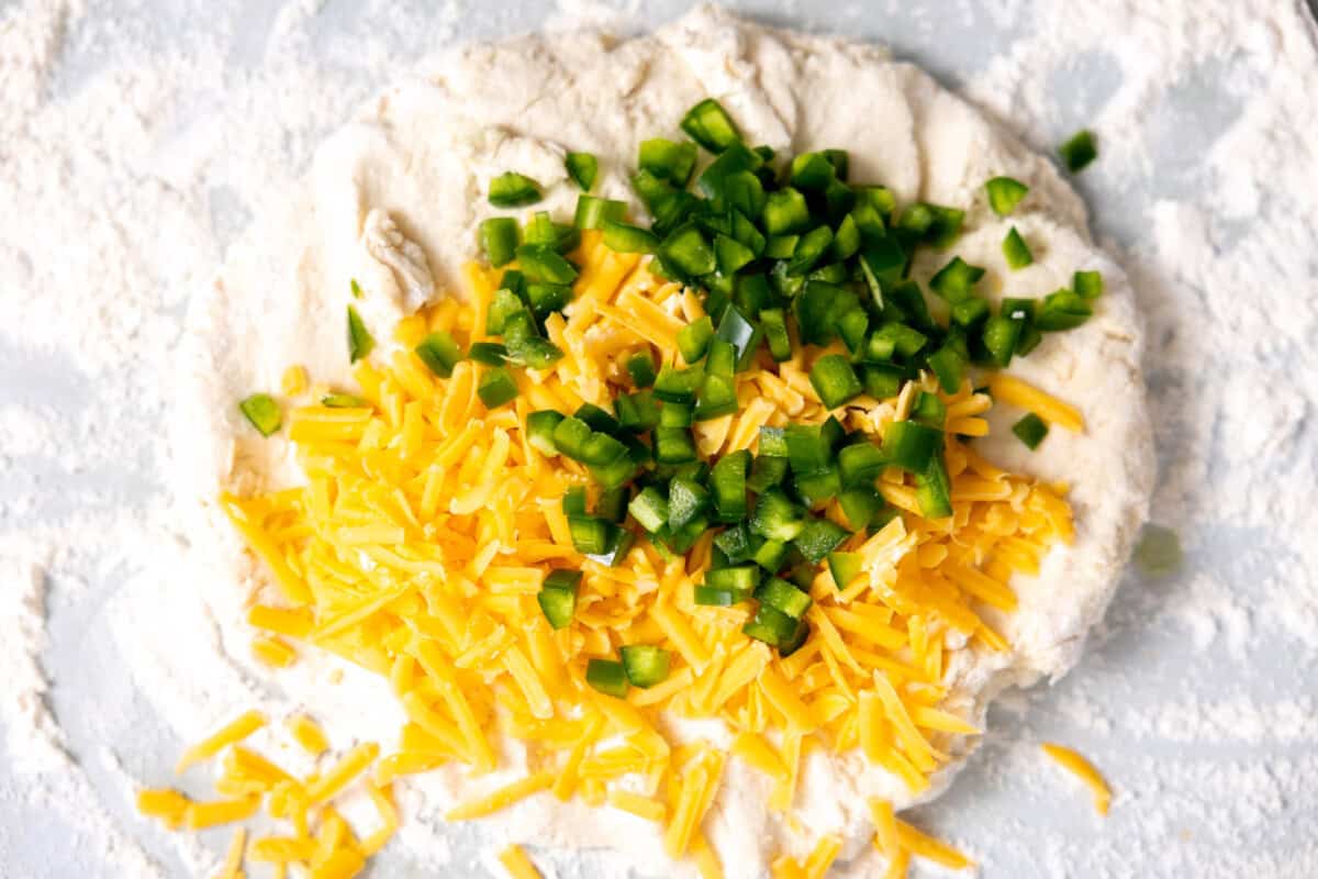 Adding cheese and jalapeno to biscuit dough. 