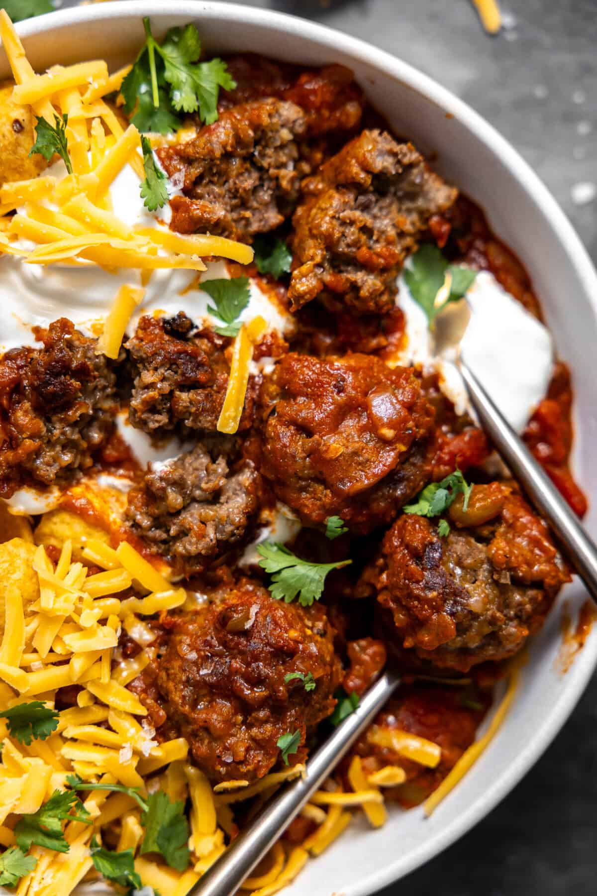 Meatball chili served over Fritos and topped with grated cheese, sour cream and cilantro.