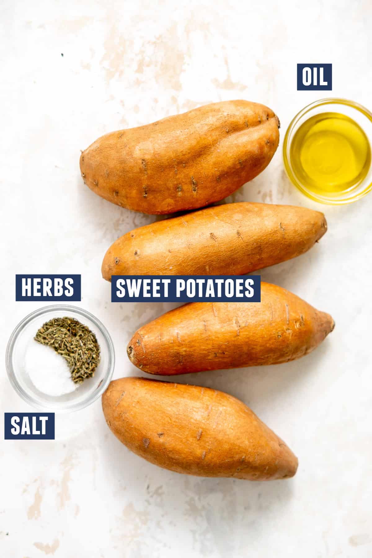 Ingredients needed to make roasted sweet potatoes. Including: sweet potatoes, olive oil, salt, and dried herbs.