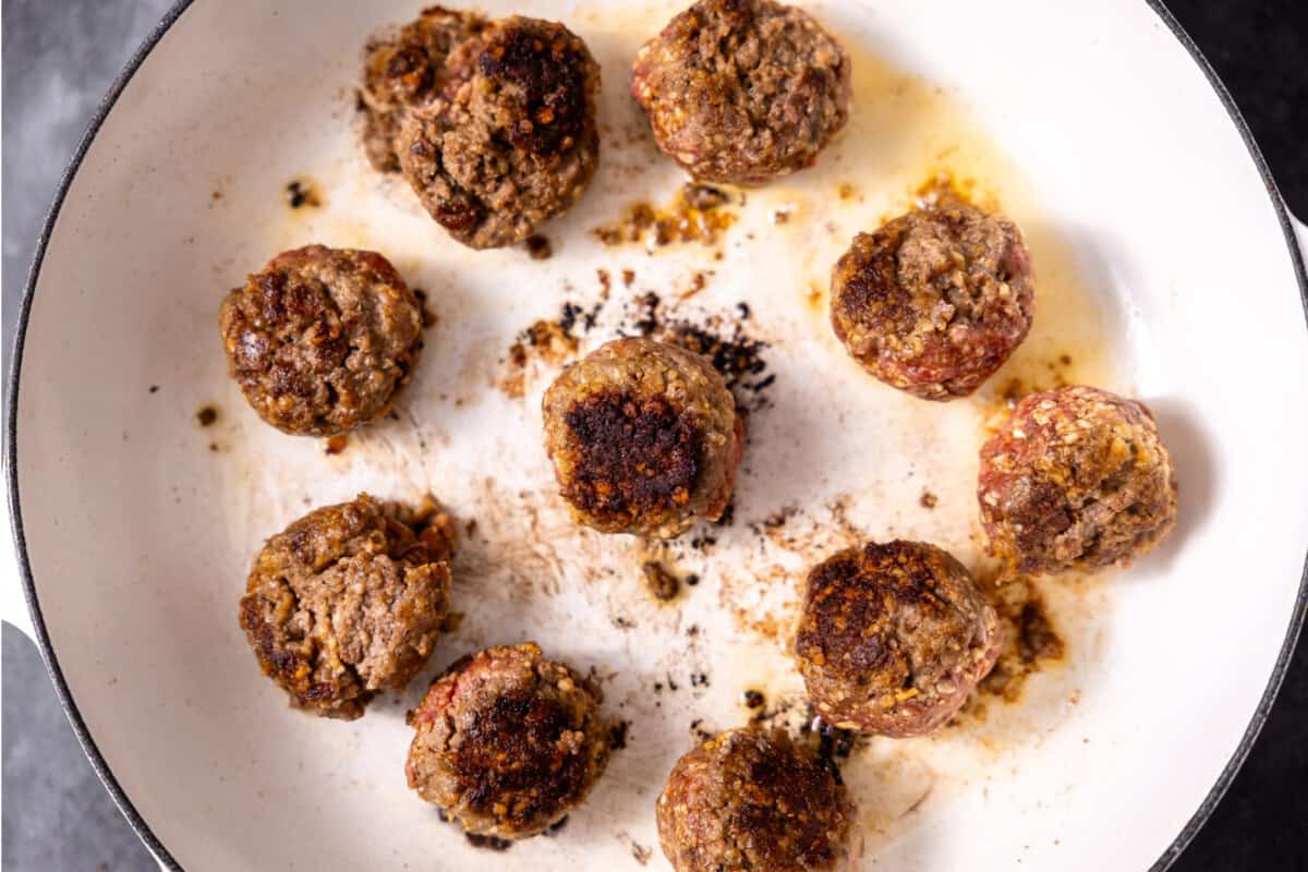 Cooking meatballs in a skillet. 