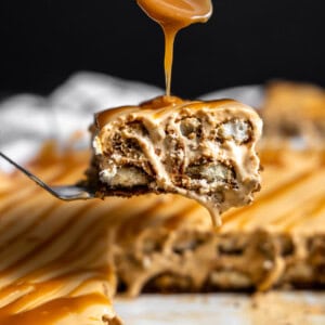 Slice of dulce de leche tiramisu being drizzled with caramel sauce on top.