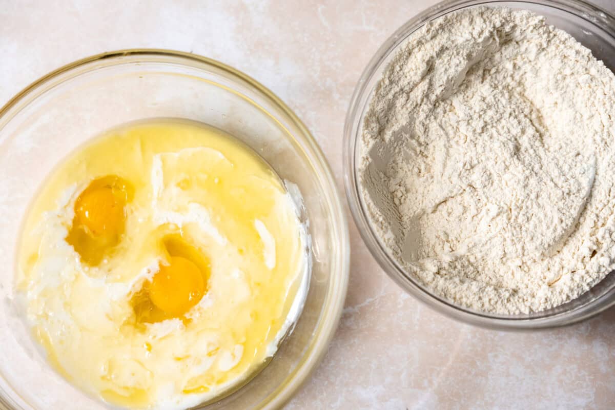 Bowl of wet ingredients and a bowl of dry ingredients ready to mix to make waffle batter. 