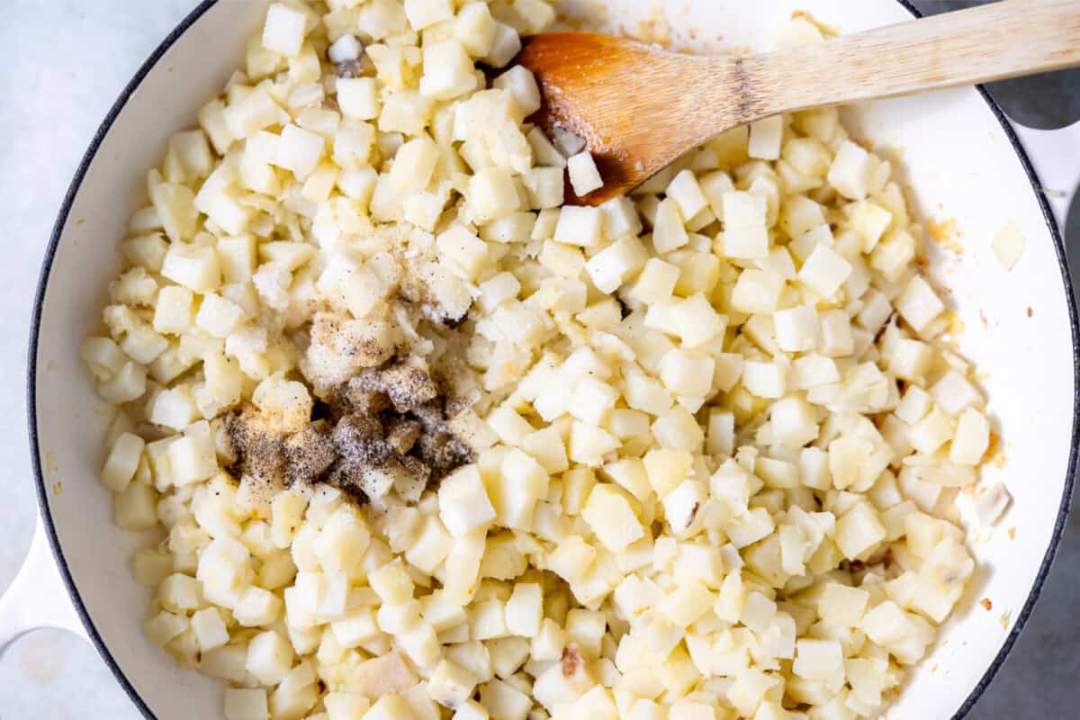 Cooking potatoes in a large skillet with seasonings. 