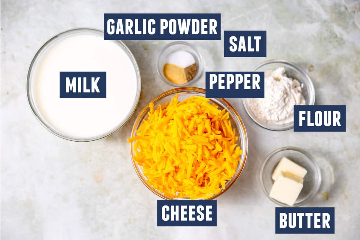 Ingredients needed to make a homemade cheese sauce laid on the counter.