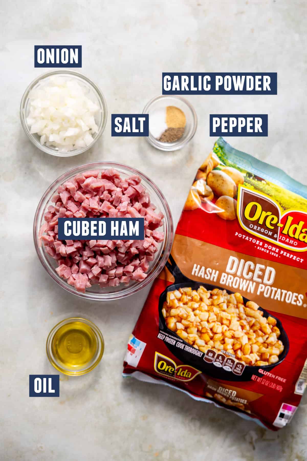 Ingredients needed to make a cheesy ham and potato casserole laid out on the counter.