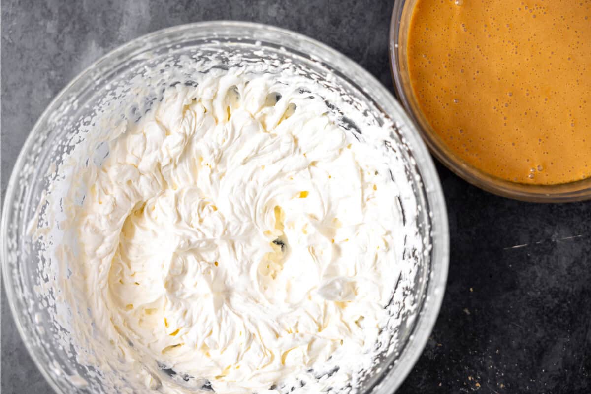 Heavy cream that has been whipped and a bowl of dulce de leche. 