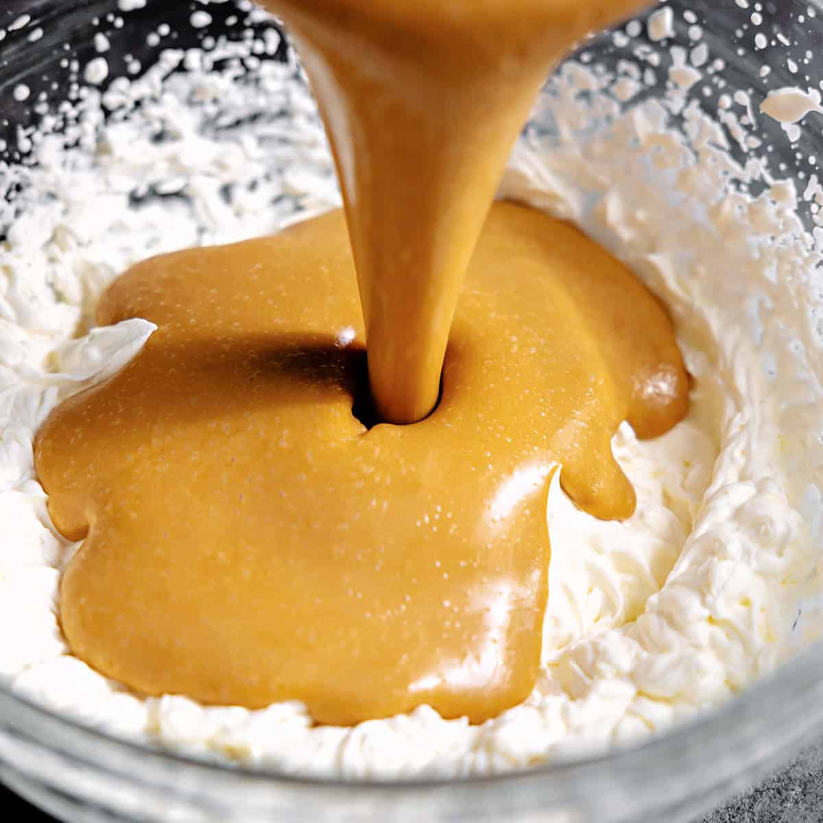 Pouring dulce de leche into whipped cream. 