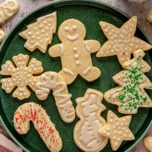 A plate with iced sugar cookies with sprinkles.