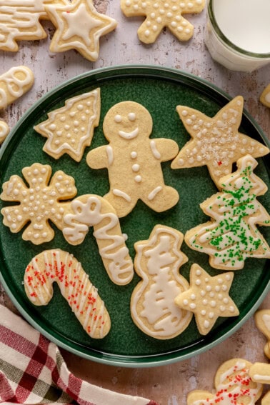 A plate with iced sugar cookies with sprinkles.