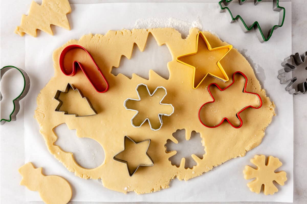 Cookie cutters cutting out cookie dough for sugar cookies. 