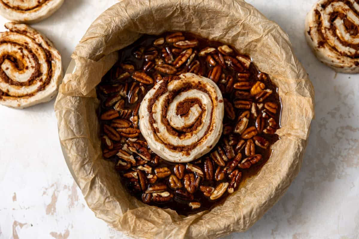 Pecans added to the brown sugar liquid and placing cinnamon rolls on top. 