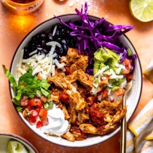 Cantina Chicken Bowls with slow roasted chicken, rice, lettuce, cabbage, pico, guacamole, and black beans.