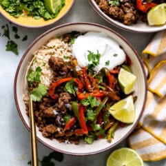 Rice bowl with ground beef fajita meat and bell peppers and onion.