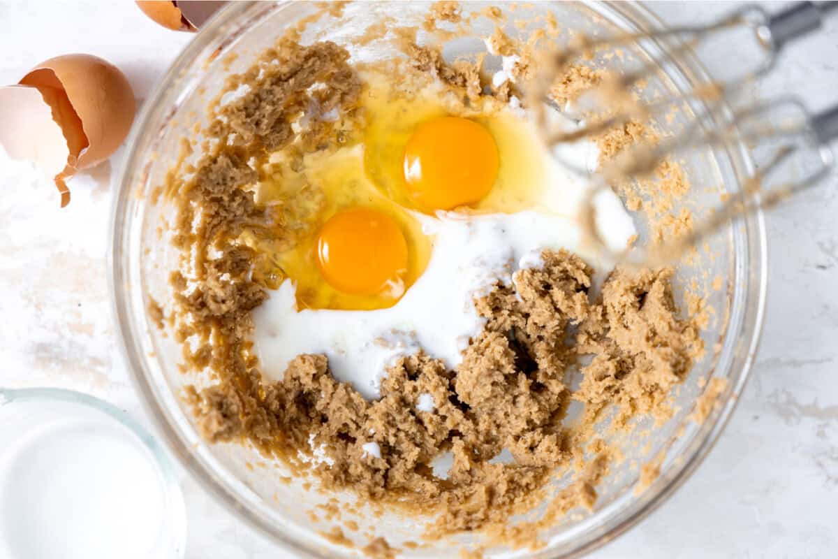 Eggs, buttermilk, and mashed banana added to mixing bowl for banana bread. 