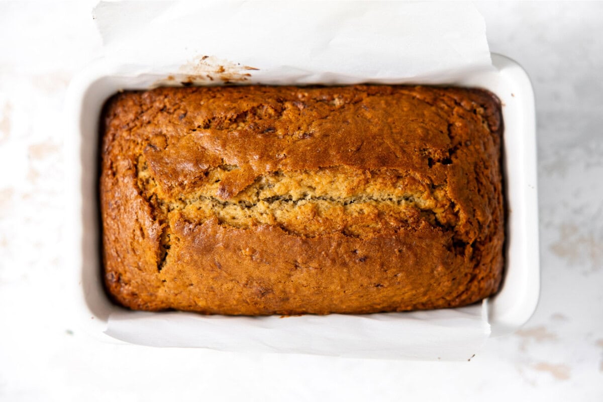 Baked banana bread in a ceramic baking dish. 