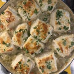 Skillet filled with chicken pot pie topped with homemade biscuits. 