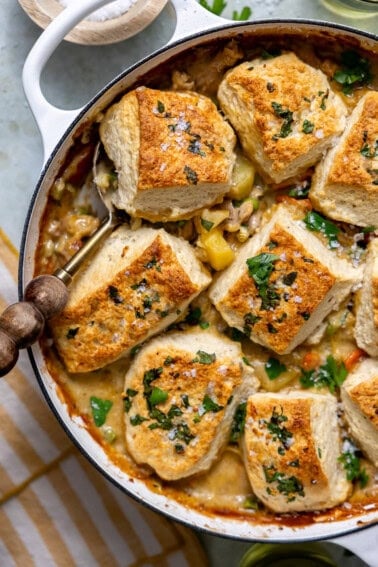 Chicken pot pie with biscuits that have a homemade garlic herb butter brushed on top.