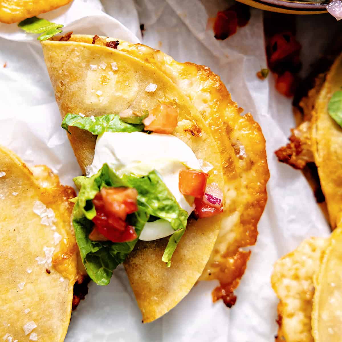 Crispy turkey tacos topped with sour cream, lettuce, and tomatoes. 