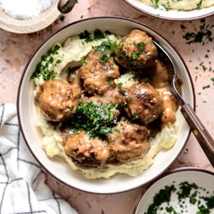 Bowl of swedish meatballs served over mashed potatoes.