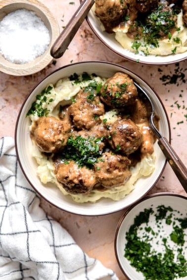 Bowl of swedish meatballs served over mashed potatoes.