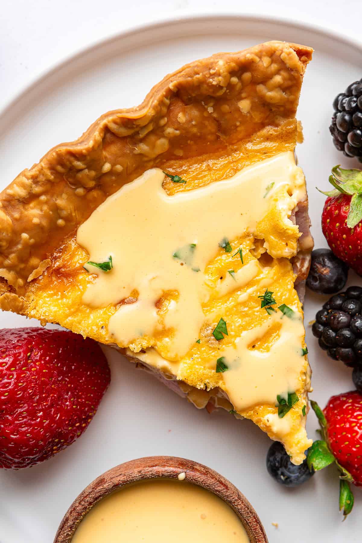 Eggs Benedict Quiche served with hollandaise sauce on top.