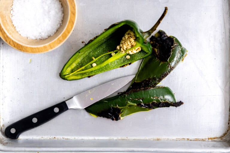 Roasted poblano being sliced in half.