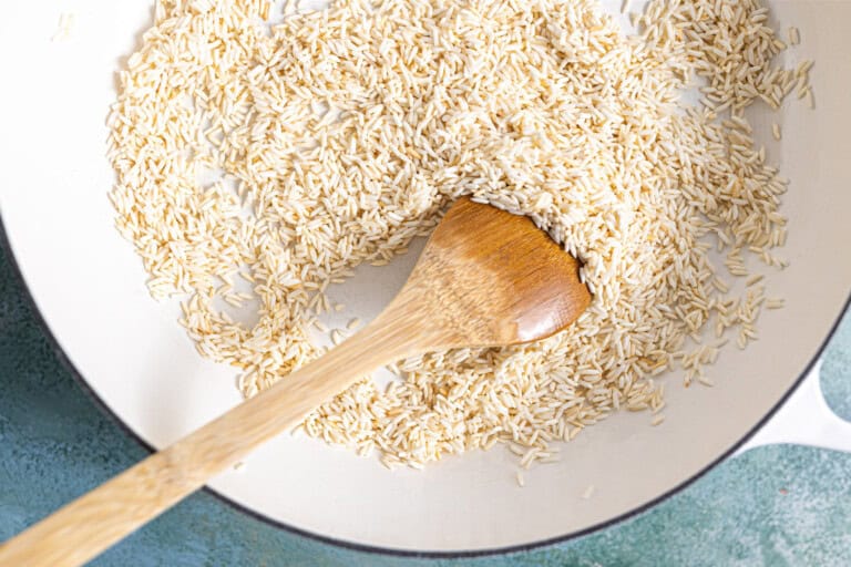 Toasting rice in a skillet with oil.