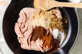 Ground chicken and seasonings in a skillet.