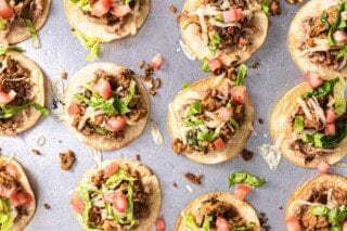 Tostadas topped with shredded lettuce and tomato.