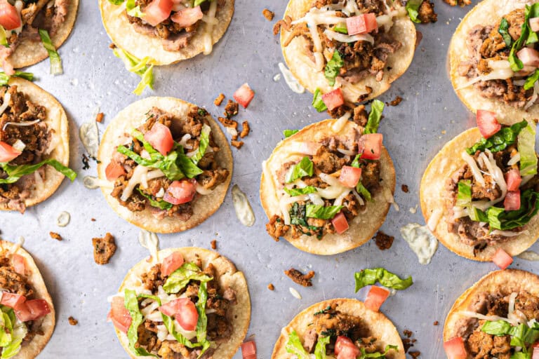 Tostadas topped with shredded lettuce and tomato.