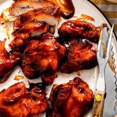 Plate of BBQ chicken being sliced.