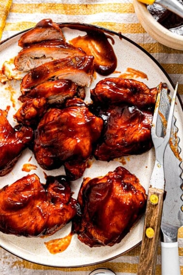 Plate of BBQ chicken being sliced.