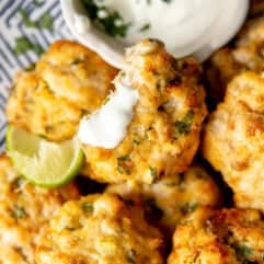 Plate of Cheesy Chicken Fritters with a cilantro dipping sauce.