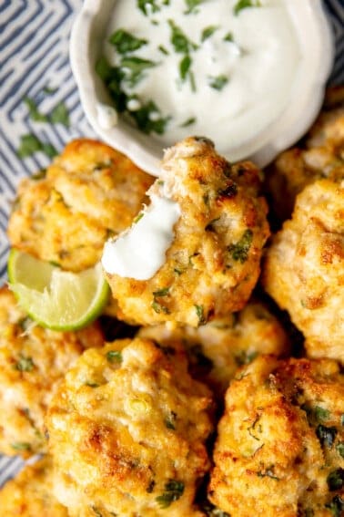 Plate of Cheesy Chicken Fritters with a cilantro dipping sauce.