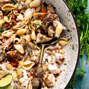 Chicken taco pasta salad served in a bowl with a wooden handled spoon.