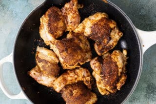 Searing chicken in a skillet for taco pasta salad.