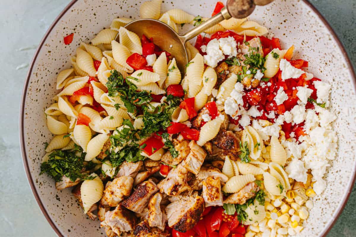 Ingredients for chicken taco pasta salad in a bowl before dressing. 