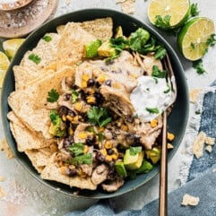 Bowl with chicken enchilada casserole served with rice and tortilla chips.