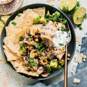 Bowl with chicken enchilada casserole served with rice and tortilla chips.