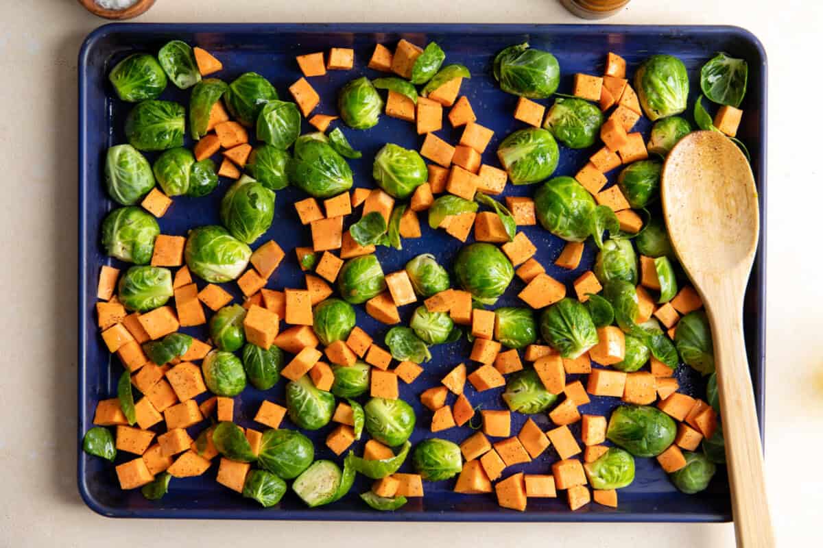 Sweet potato and Brussels sprouts on a baking sheet.