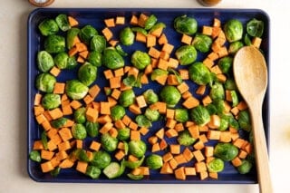 Sweet potato and Brussels sprouts on a baking sheet.