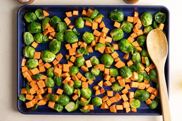 Sweet potato and Brussels sprouts on a baking sheet.