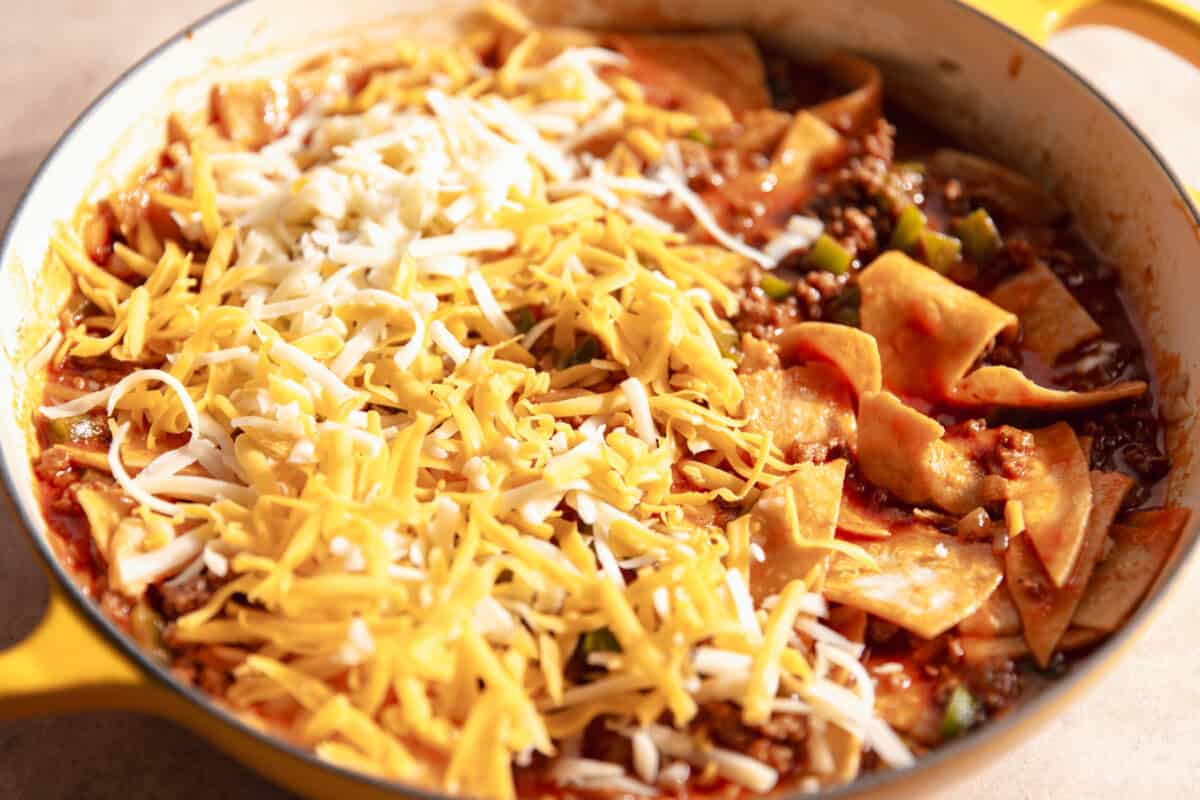Enchilada skillet topped with grated cheese before baking. 