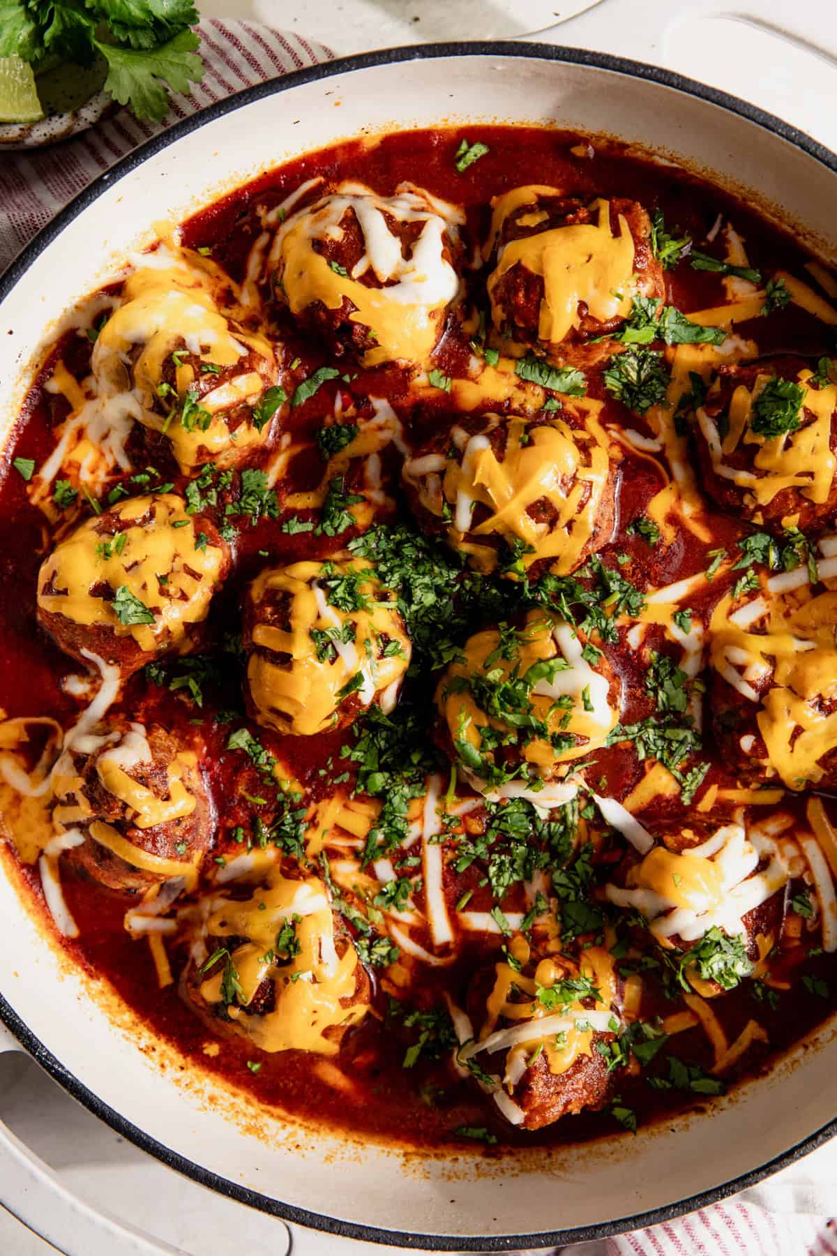 Enchilada meatball skillet topped with melted cheese. 