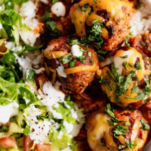 Up close of cooked enchilada meatballs served over rice.